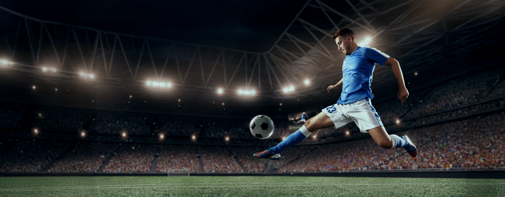 futebolista em campo, a chutar a bola, num estádio cheio